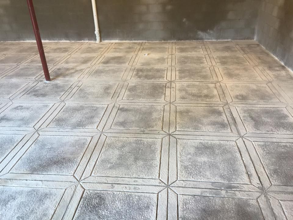 A concrete floor with a pattern of squares on it.