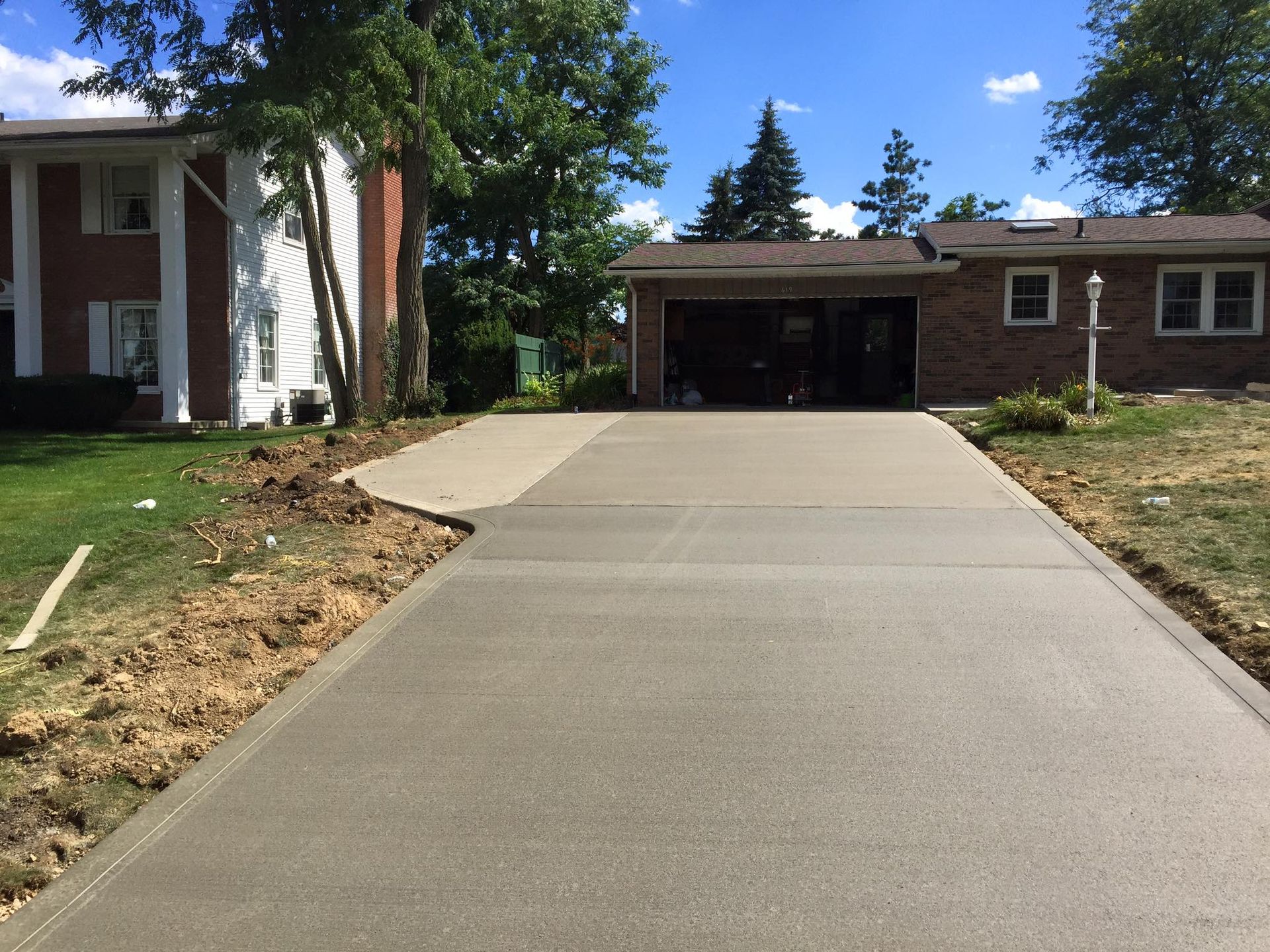 A brick house with a concrete driveway leading to it