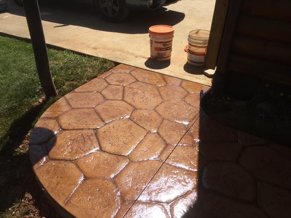 Two orange buckets are sitting next to a concrete walkway