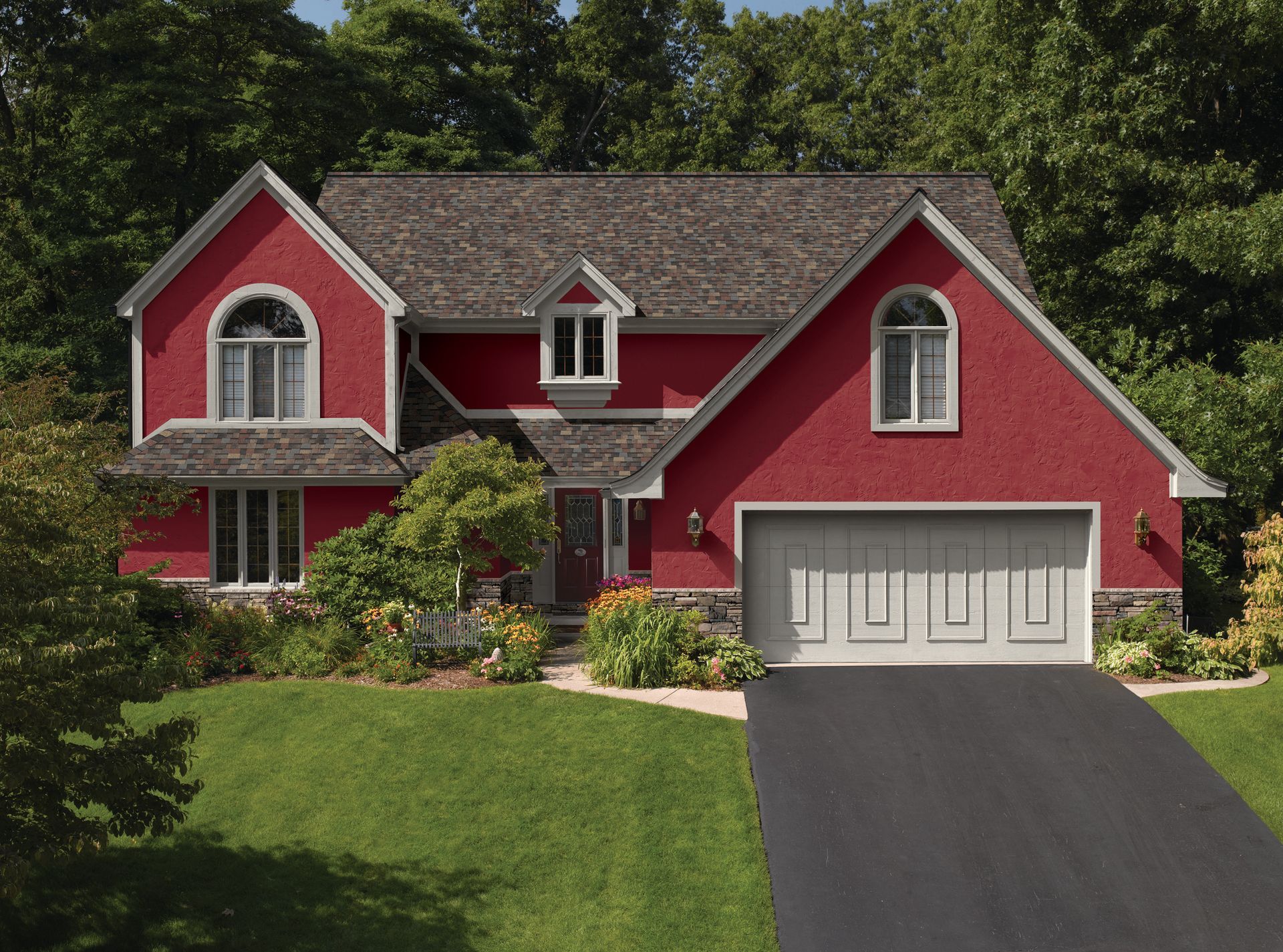 A white house with a lot of windows and a garden in front of it.