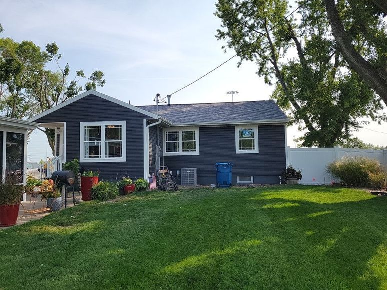 A small house with a large lawn in front of it