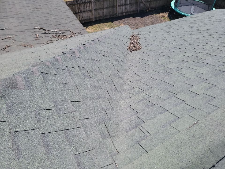 A close up of a roof with a trampoline in the background.