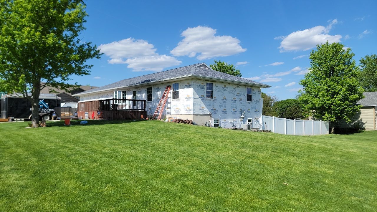 A house is being built in the middle of a lush green field.