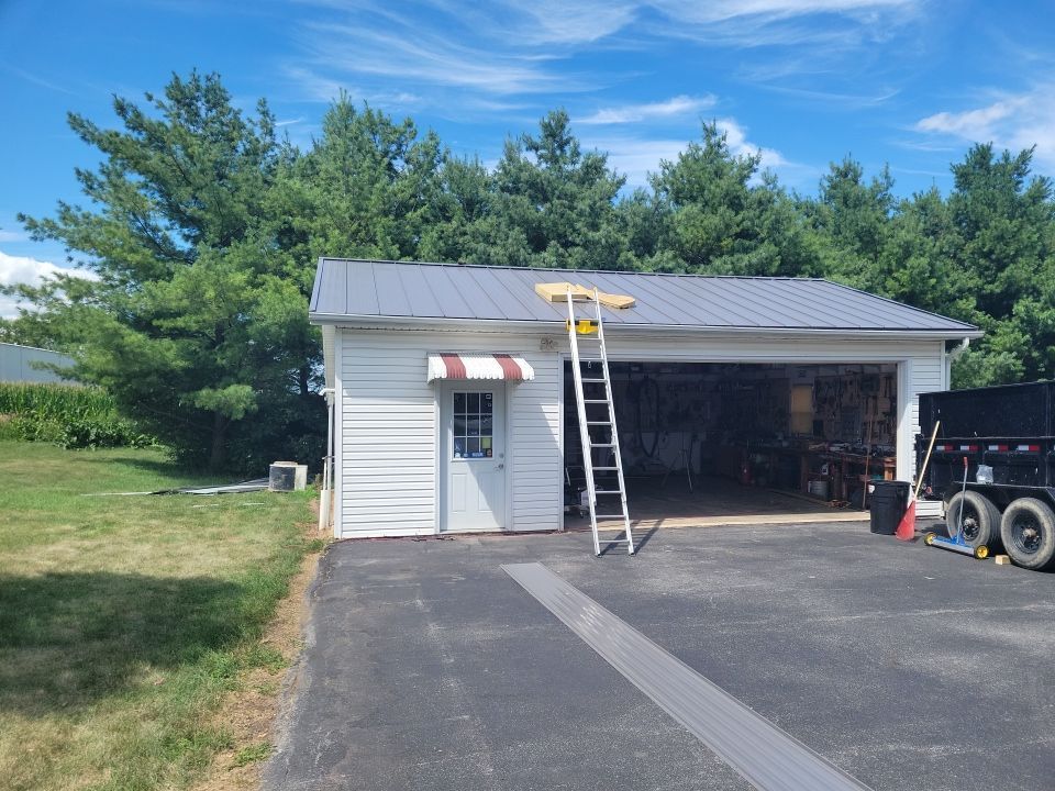 A white garage with a ladder attached to the side of it.