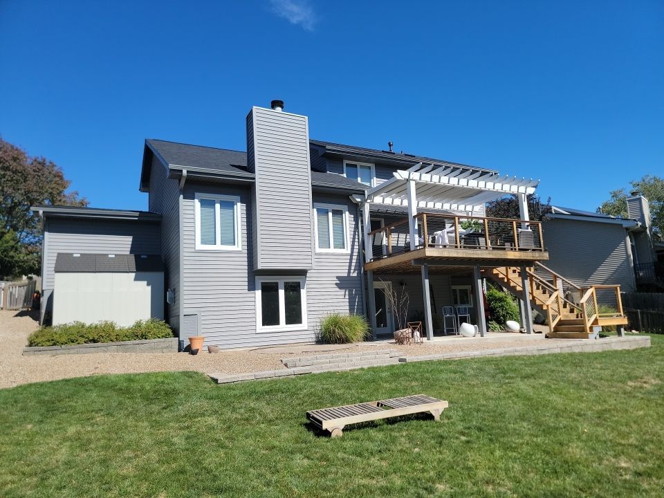 The back of a house with a large deck and stairs.