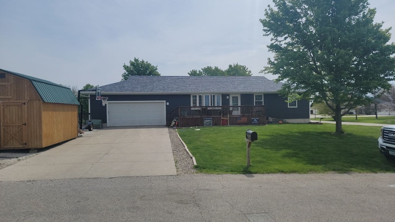 A house with a garage and a shed in front of it.