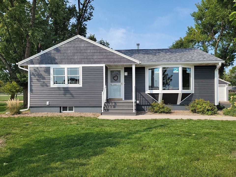 A small house with a large lawn in front of it.