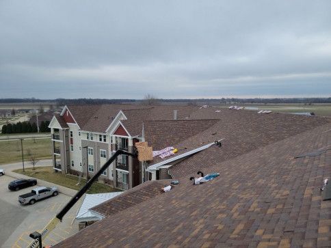 A crane is working on the roof of a building.