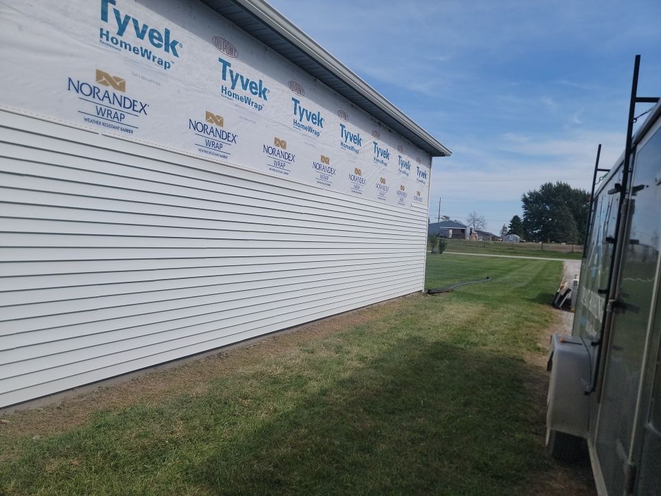 A trailer is parked in front of a building that is being built.