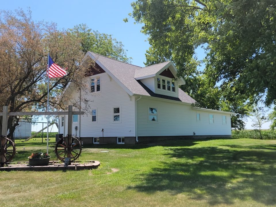A white house with a wagon wheel in front of it