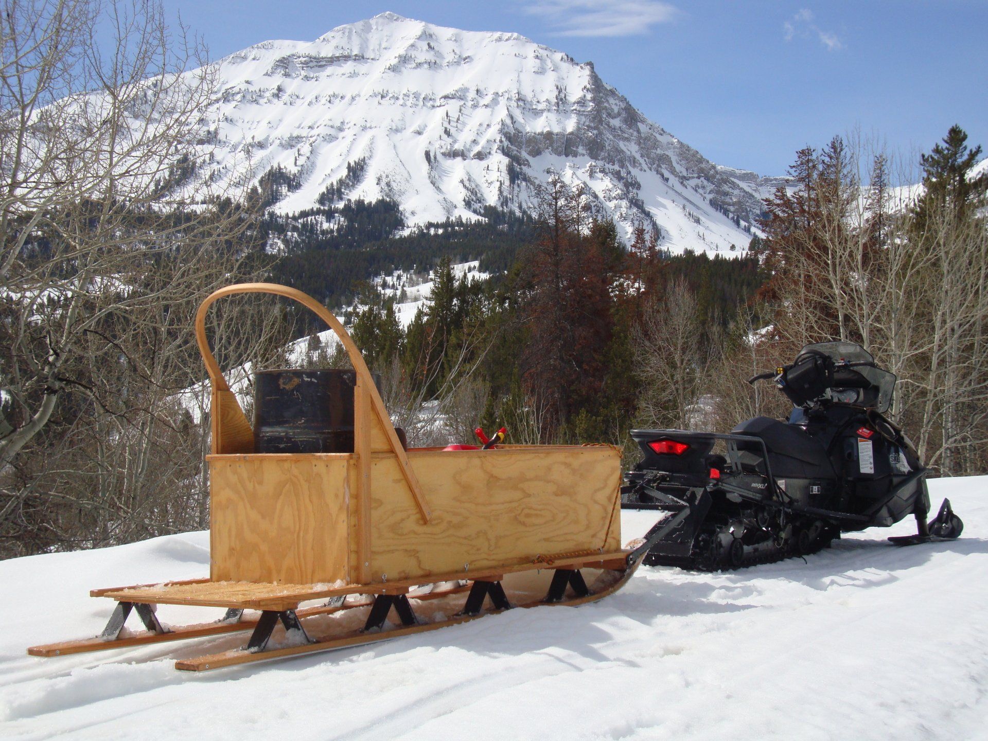 A snowmobile with a wooden sled attached to it