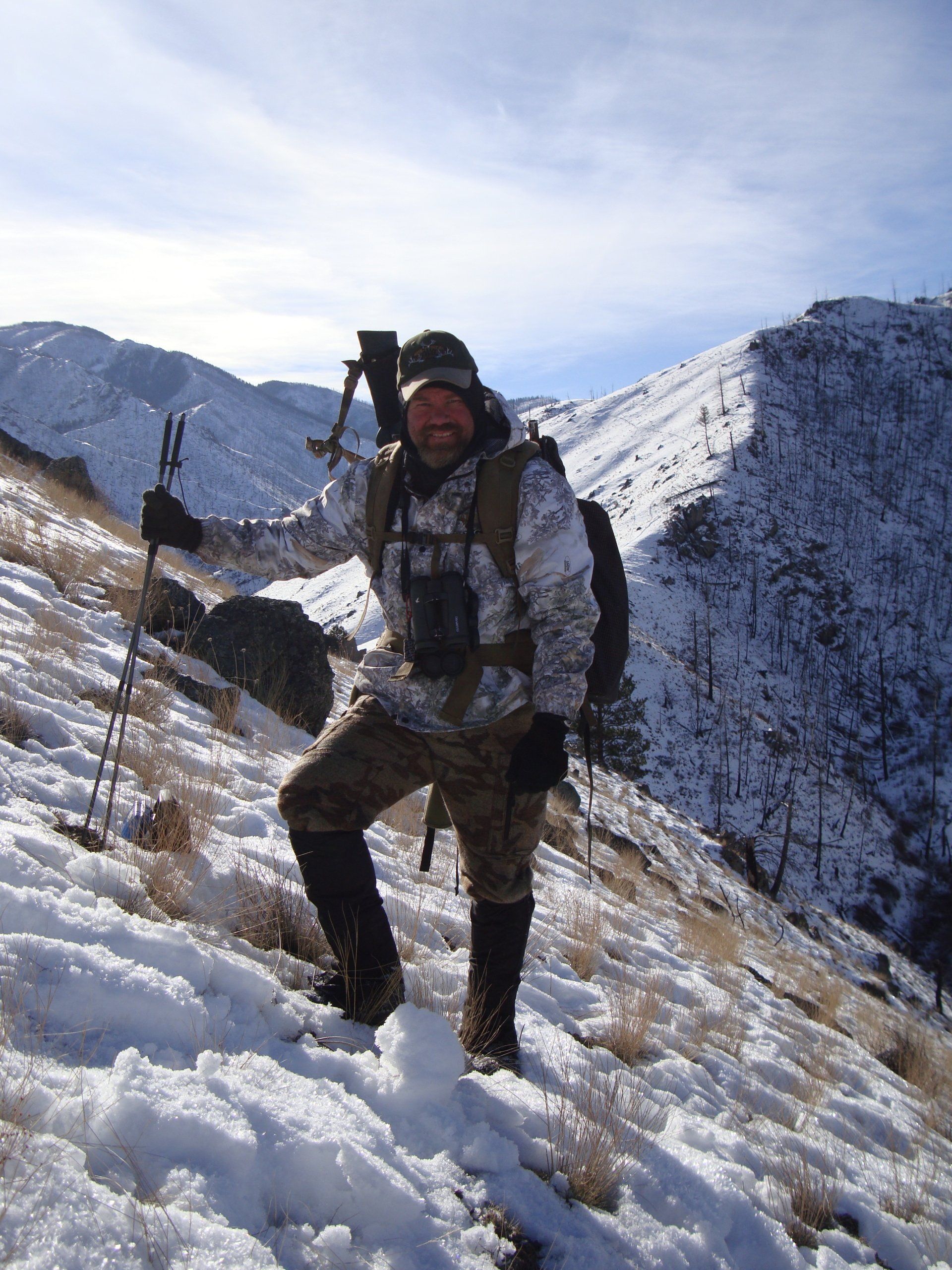 A man standing on a snowy hill with a backpack