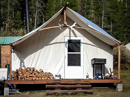 A white tent is sitting in the middle of a field