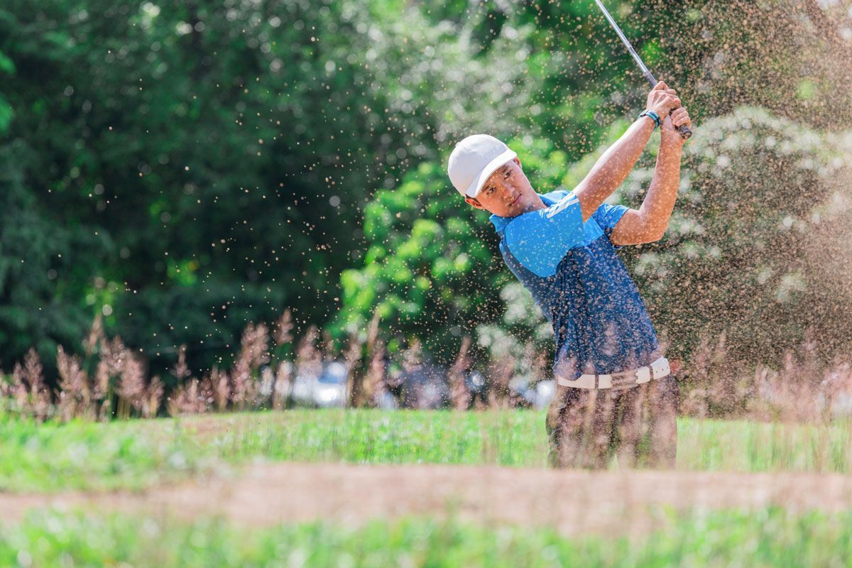 Golfer hard swing in field