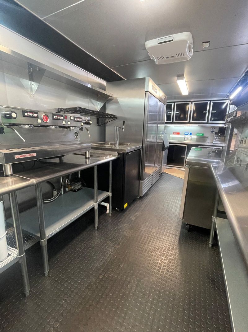 A kitchen with a lot of stainless steel appliances and counter tops.