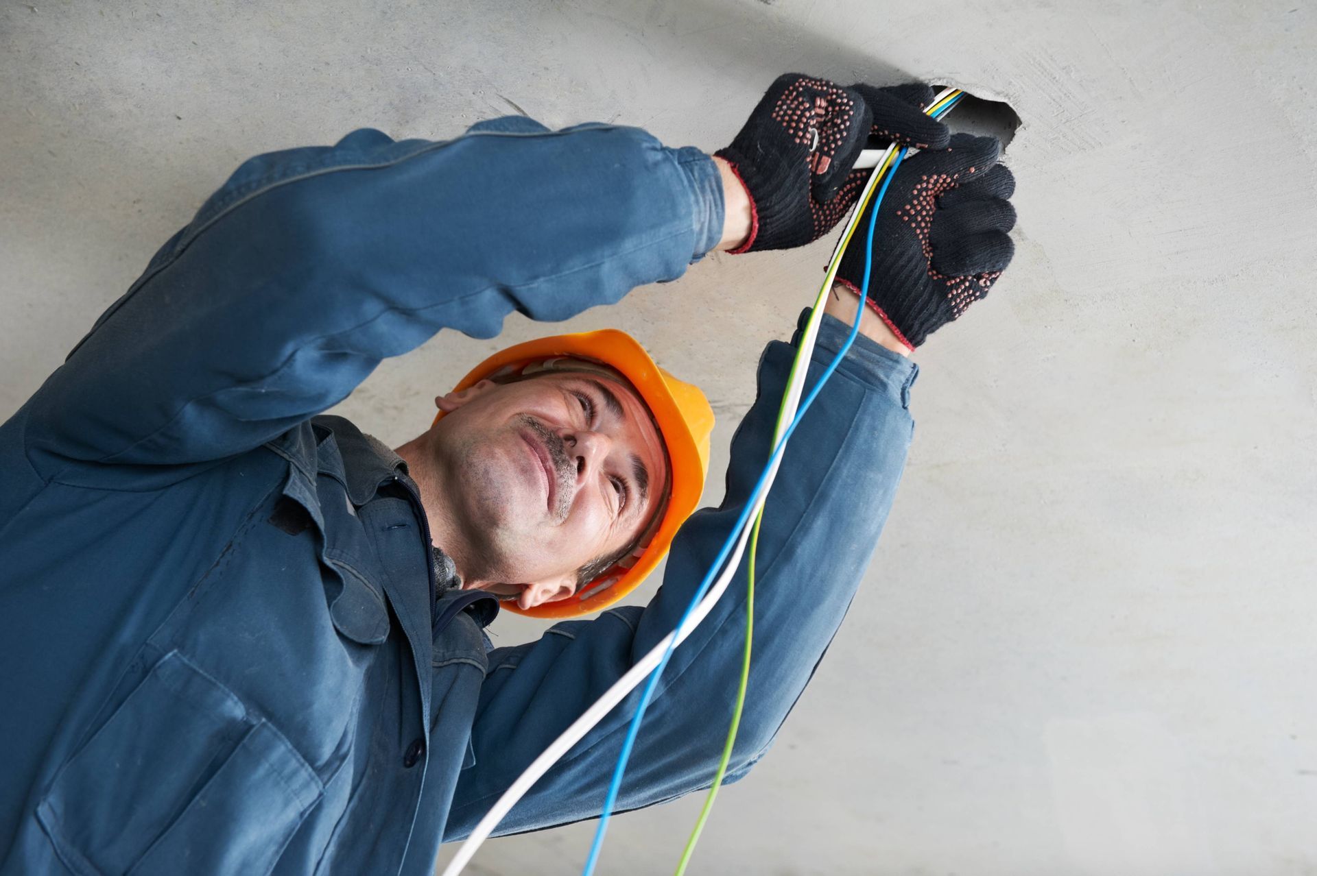 a man in a hard hat is working on a ceiling .