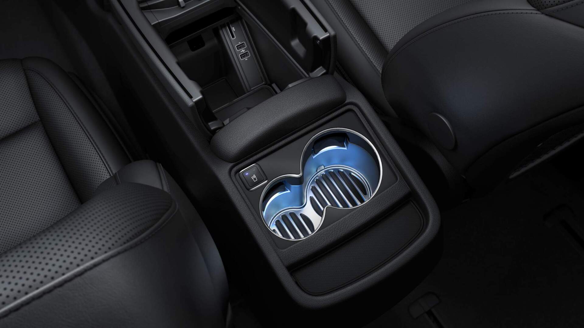 Une console de voiture avec deux porte-gobelets et une télécommande.