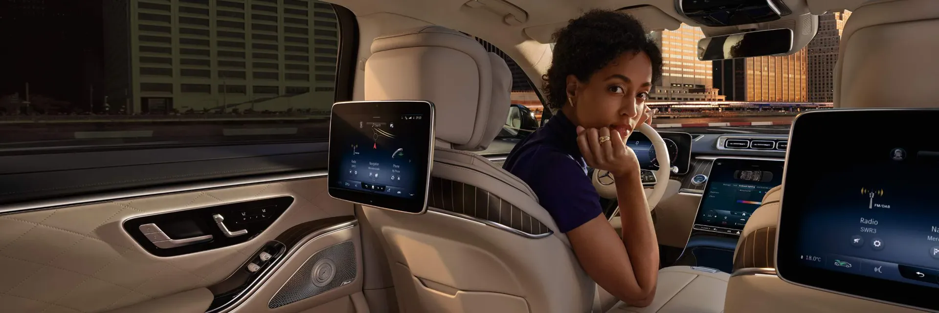 Une femme est assise sur le siège arrière d'une voiture.