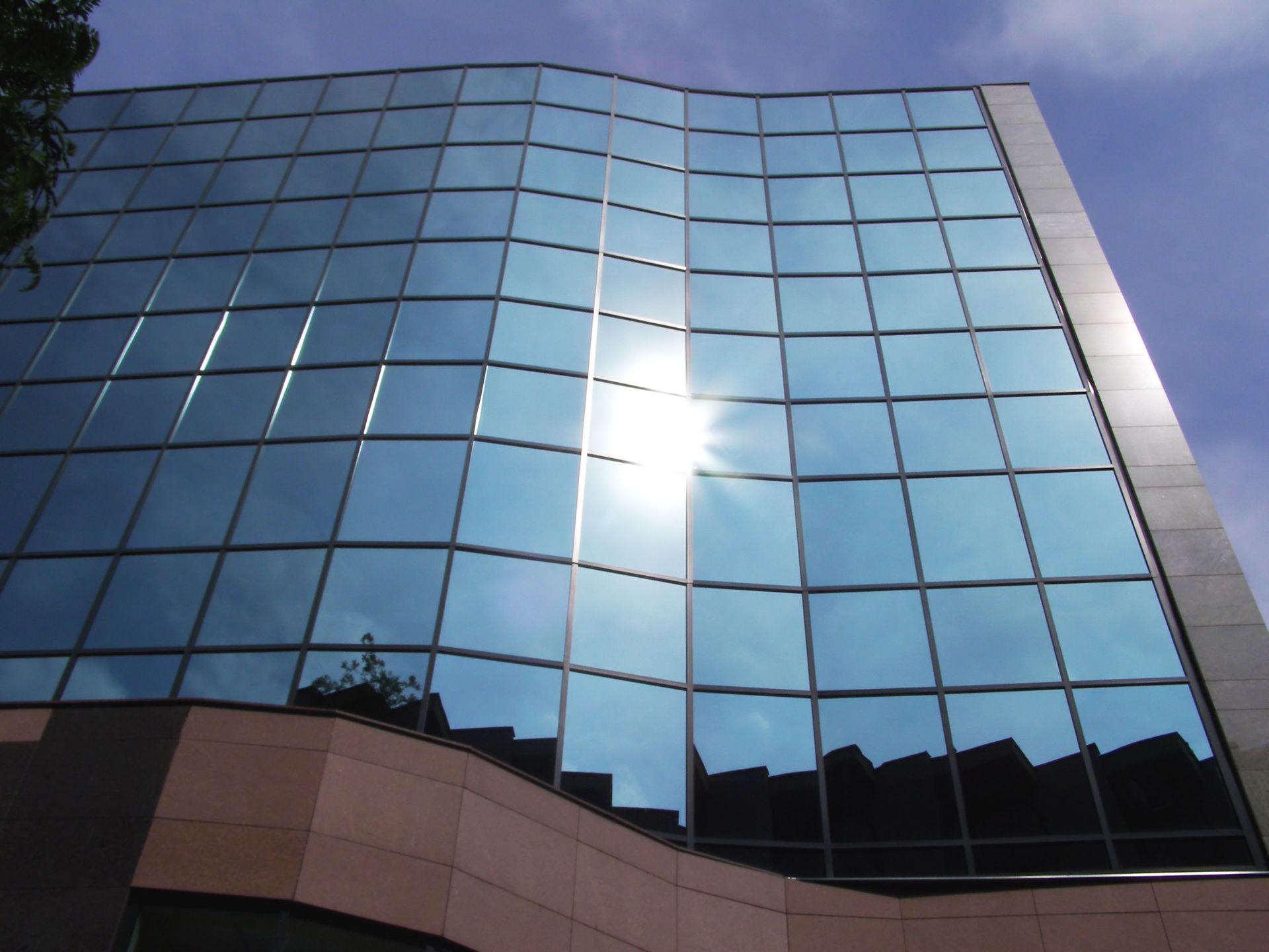 The sun is reflected in the windows of a building