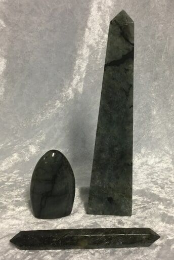 A Black Stone and A Green Stone Placed Side by Side on A Neutral Background — Crystal Cauldron In South Mackay, QLD