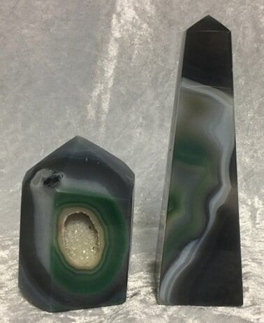 Two Black and Green Agate Stones Resting on A Smooth White Surface — Crystal Cauldron In South Mackay, QLD