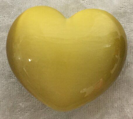 A Yellow Heart-Shaped Glass Rests Elegantly on A White Cloth — Crystal Cauldron In South Mackay, QLD