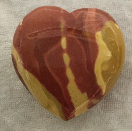 A Heart-Shaped Stone Featuring a Vibrant Red and Yellow Stripe — Crystal Cauldron In South Mackay, QLD