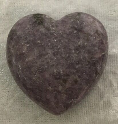 A Purple Heart-Shaped Stone Resting on A Textured Cloth — Crystal Cauldron In South Mackay, QLD