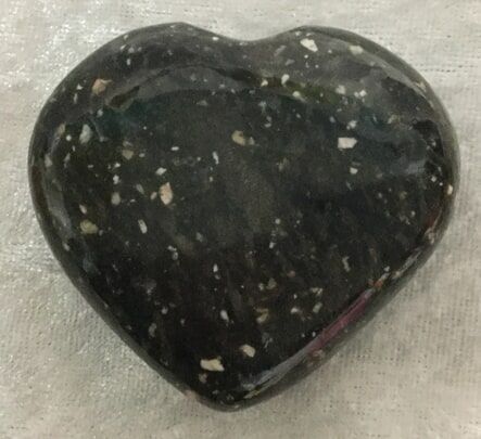 A Black Heart-Shaped Stone Featuring a Speckled Texture — Crystal Cauldron In South Mackay, QLD