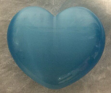 A Blue Heart-Shaped Glass Rests Elegantly on A White Cloth — Crystal Cauldron In South Mackay, QLD