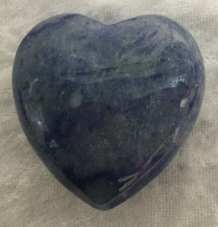 A Blue Heart-Shaped Stone Rests Elegantly on A White Cloth — Crystal Cauldron In South Mackay, QLD