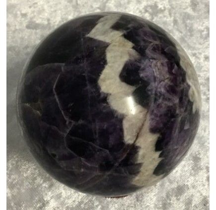 A Polished Crystal Sphere With a Purple and White Zigzag Pattern — Crystal Cauldron In South Mackay, QLD