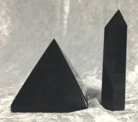 Two Black Pyramid-Shaped Objects Positioned on A Clean White Surface — Crystal Cauldron In South Mackay, QLD