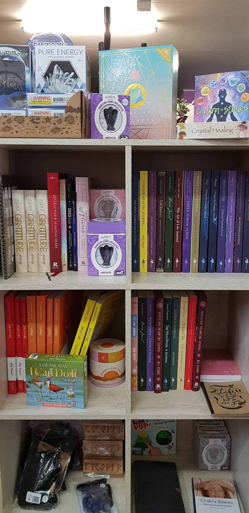 A Bookshelf Filled with Lots of Books and Toys — Crystal Cauldron in South Mackay, QLD