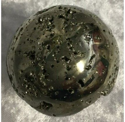A Shiny, Round Pyrite Sphere With a Metallic Surface — Crystal Cauldron In South Mackay, QLD