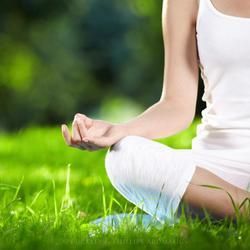 A Person in A White Outfit Sits Cross-Legged on Grass — Crystal Cauldron In South Mackay, QLD
