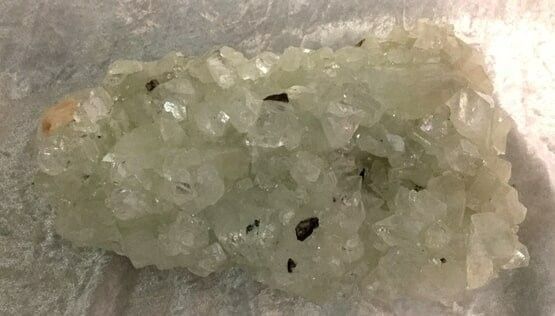 A Large Green Crystal Rests on A Surface — Crystal Cauldron In South Mackay, QLD