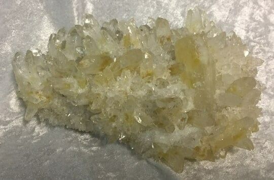 A Cluster of Pale Yellow Quartz Crystals Rests on a Light Fabric Surface — Crystal Cauldron In South Mackay, QLD