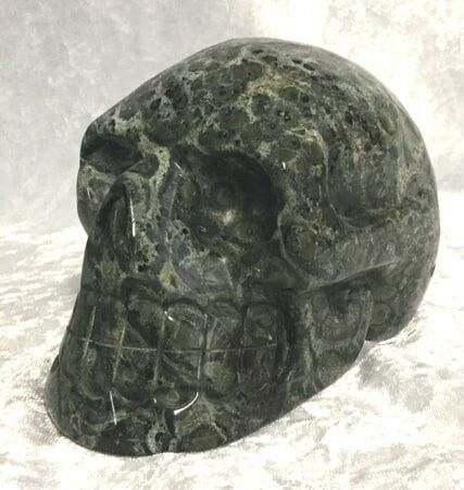 A Green Marble Skull Positioned on A White Cloth — Crystal Cauldron In South Mackay, QLD