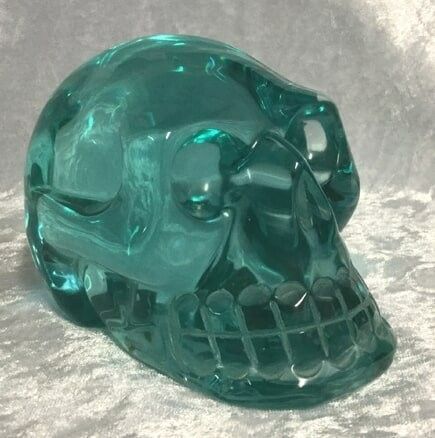 A Green Glass Skull, Showcasing Intricate Details and A Glossy Finish — Crystal Cauldron In South Mackay, QLD