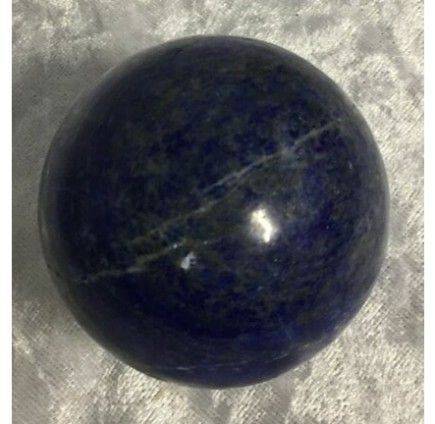 A Polished, Dark Blue Spherical Gemstone With Lighter Striations — Crystal Cauldron In South Mackay, QLD