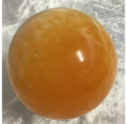 A Shiny, Spherical Orange Calcite Gemstone — Crystal Cauldron In South Mackay, QLD