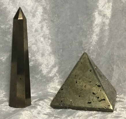 Two Small Metal Pyramids Positioned Side by Side on A Neutral Background — Crystal Cauldron In South Mackay, QLD