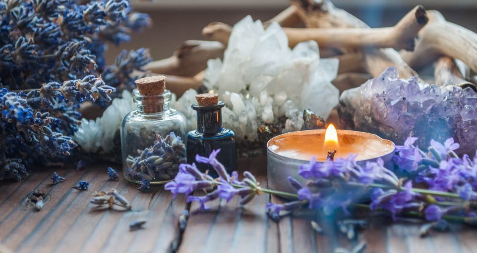 A Wooden Table Topped with Candles and Bottles of Essential Oils — Crystal Cauldron in South Mackay, QLD