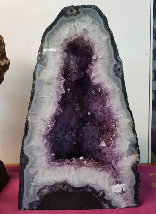 A Large Amethyst Geode Is Sitting on A Pink Table — Crystal Cauldron in South Mackay, QLD