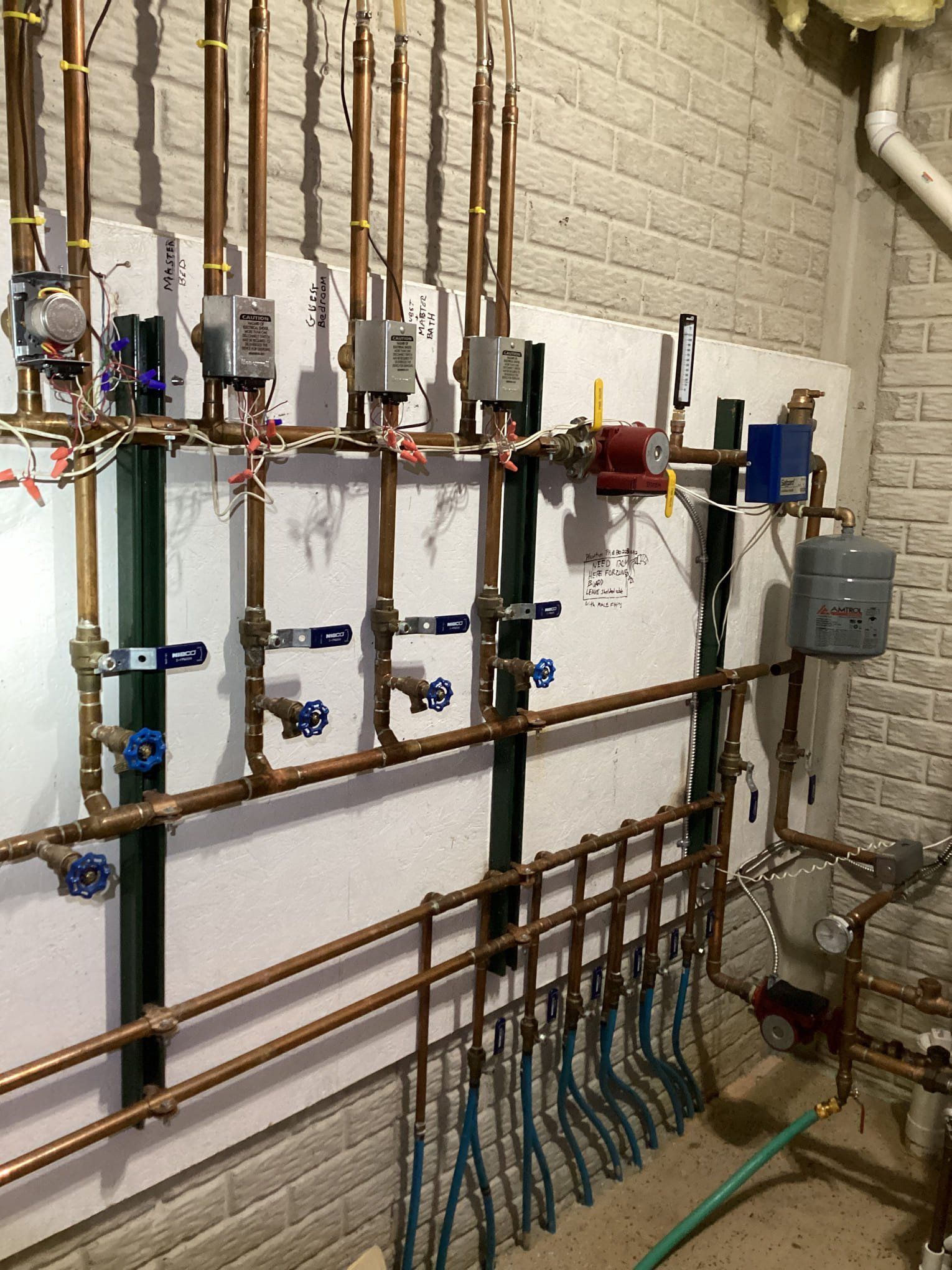 A room with a lot of copper pipes hanging on the wall.