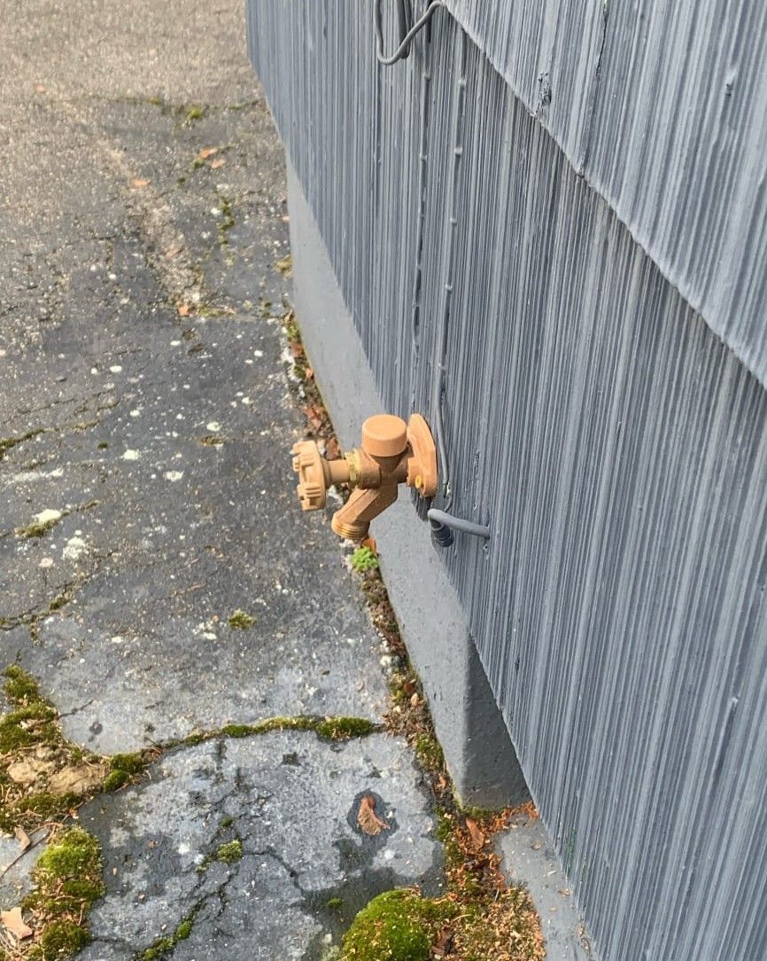 A faucet is attached to the side of a building.