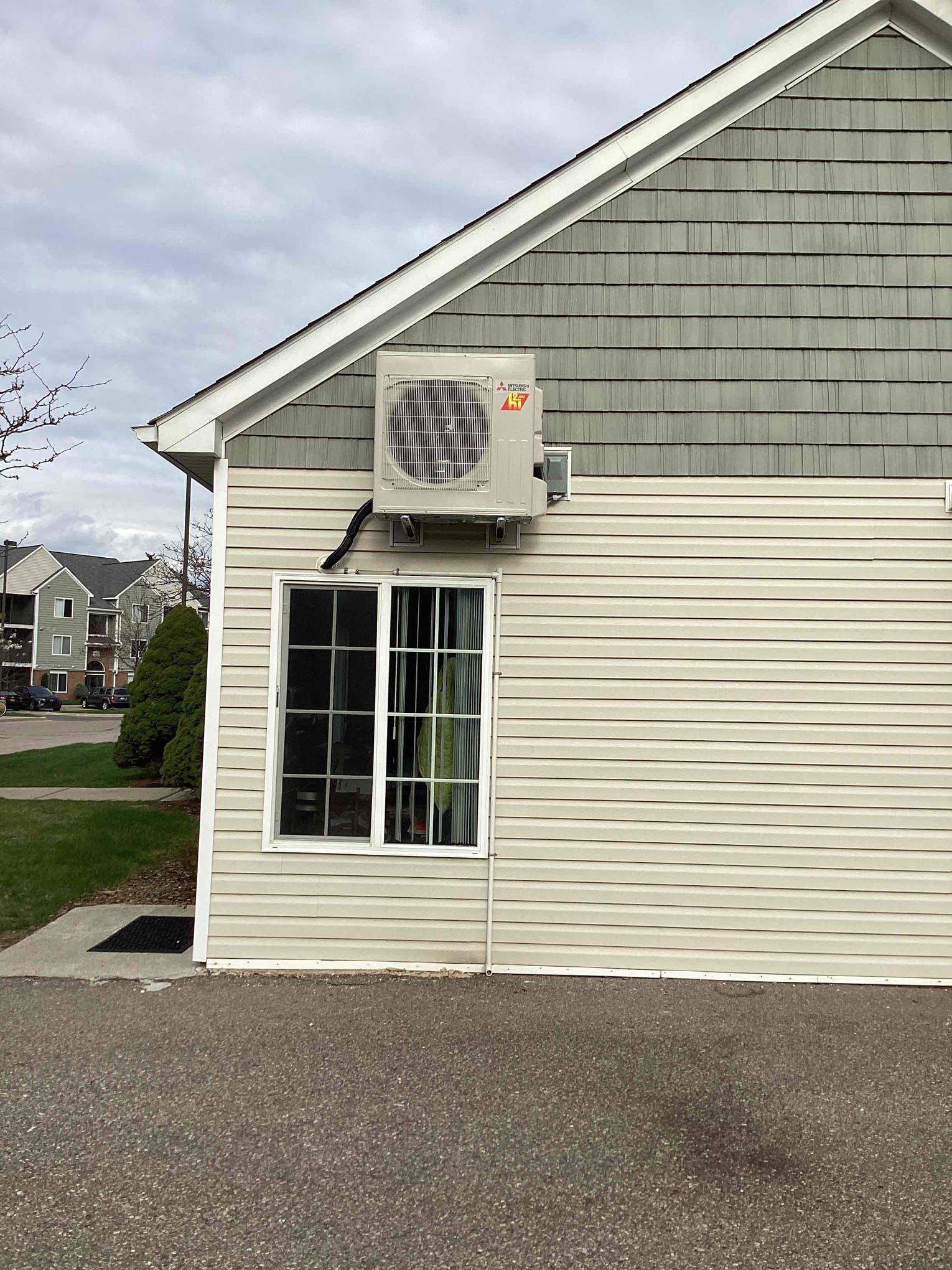 A house with a window and an air conditioner on the side of it.