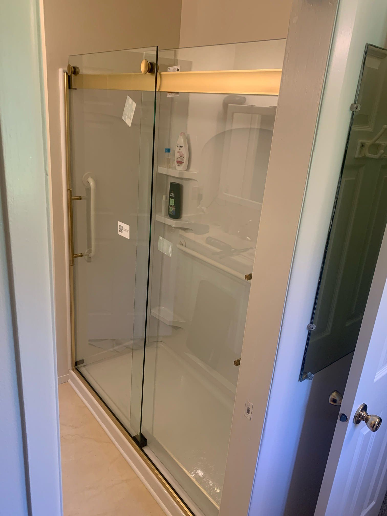 A bathroom with a sliding glass shower door and a mirror.