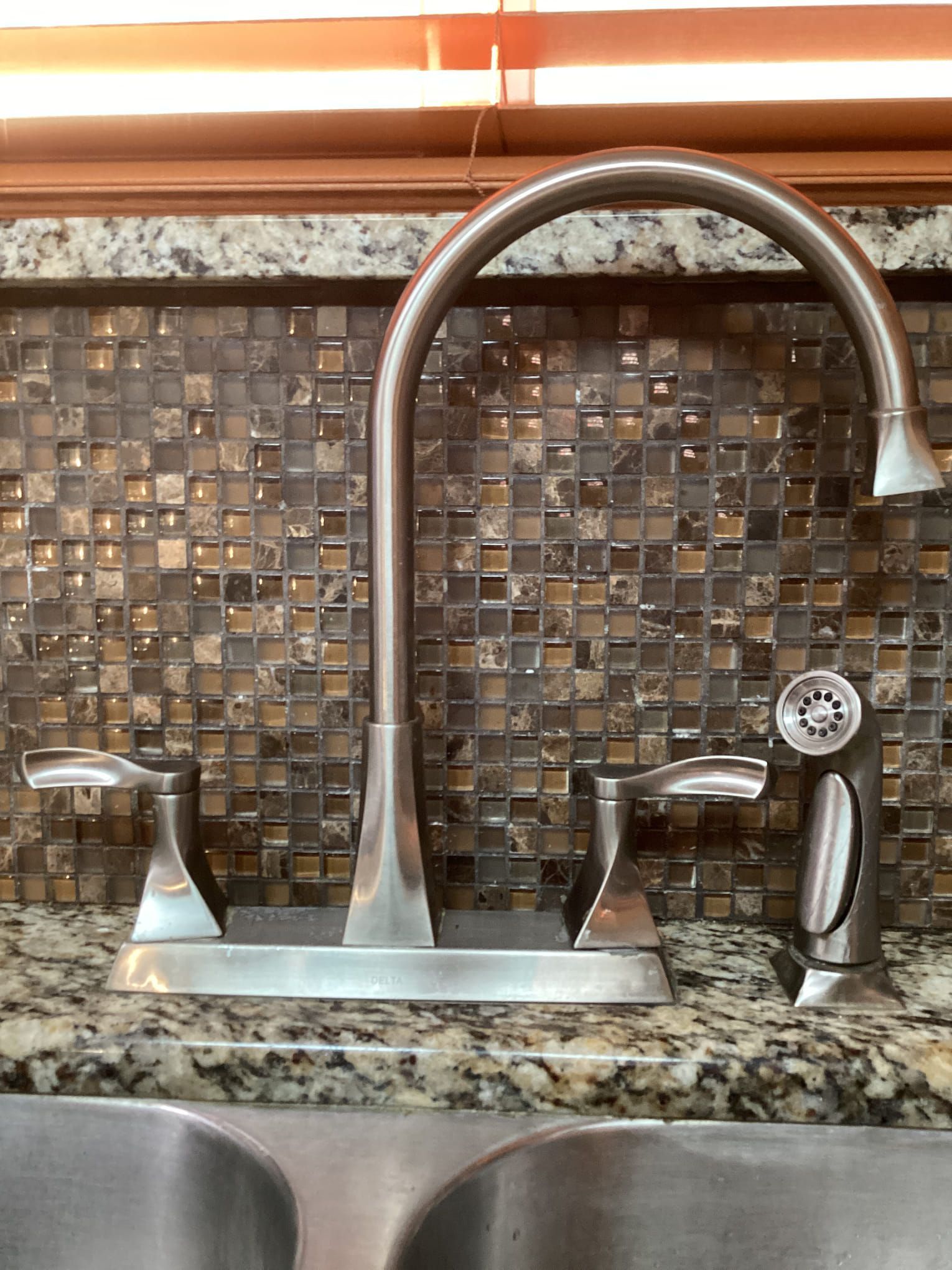 A kitchen sink with a faucet on top of it